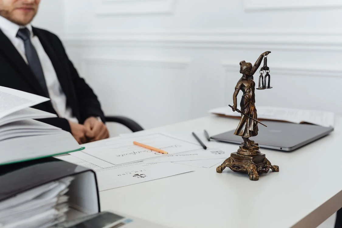Sitting lawyer with lady justice on top of the table